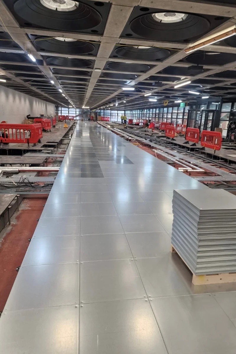 Raised access flooring installation in progress across a large commercial interior space